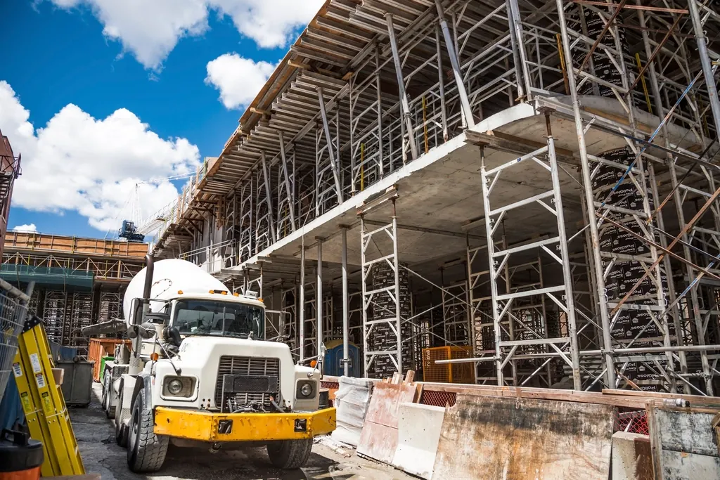Commercial building under construction with scaffolding and a concrete truck